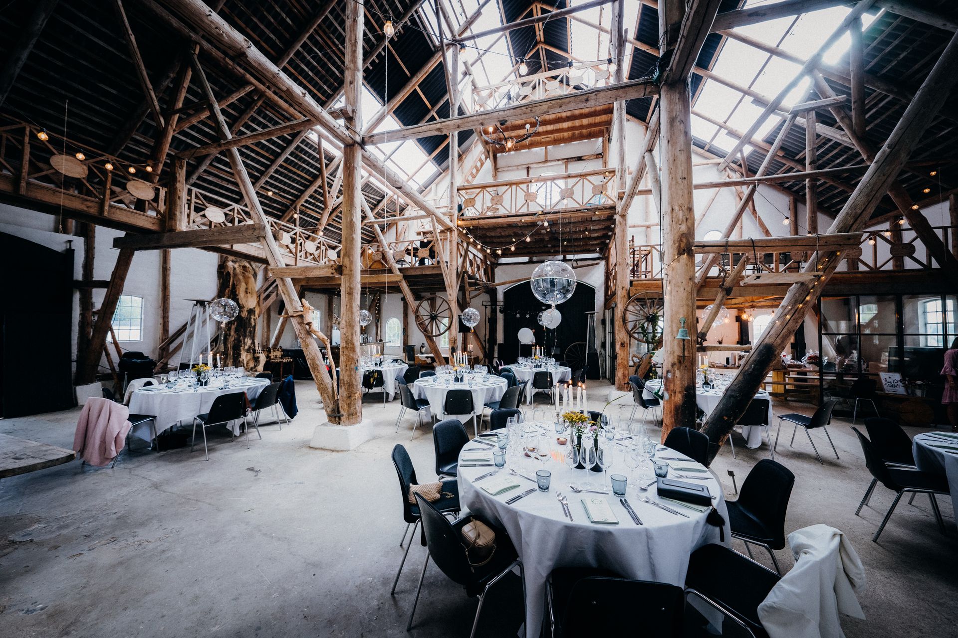 Salón rústico con vigas de madera y mesas redondas